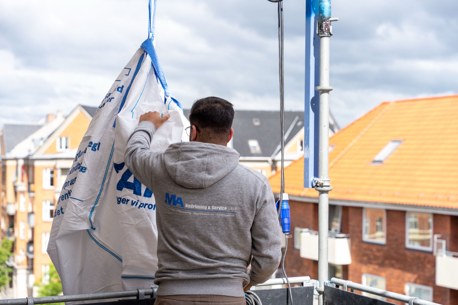 Asbest-arbejder med sikkerhedsdragt og harness fjerner asbesttag
